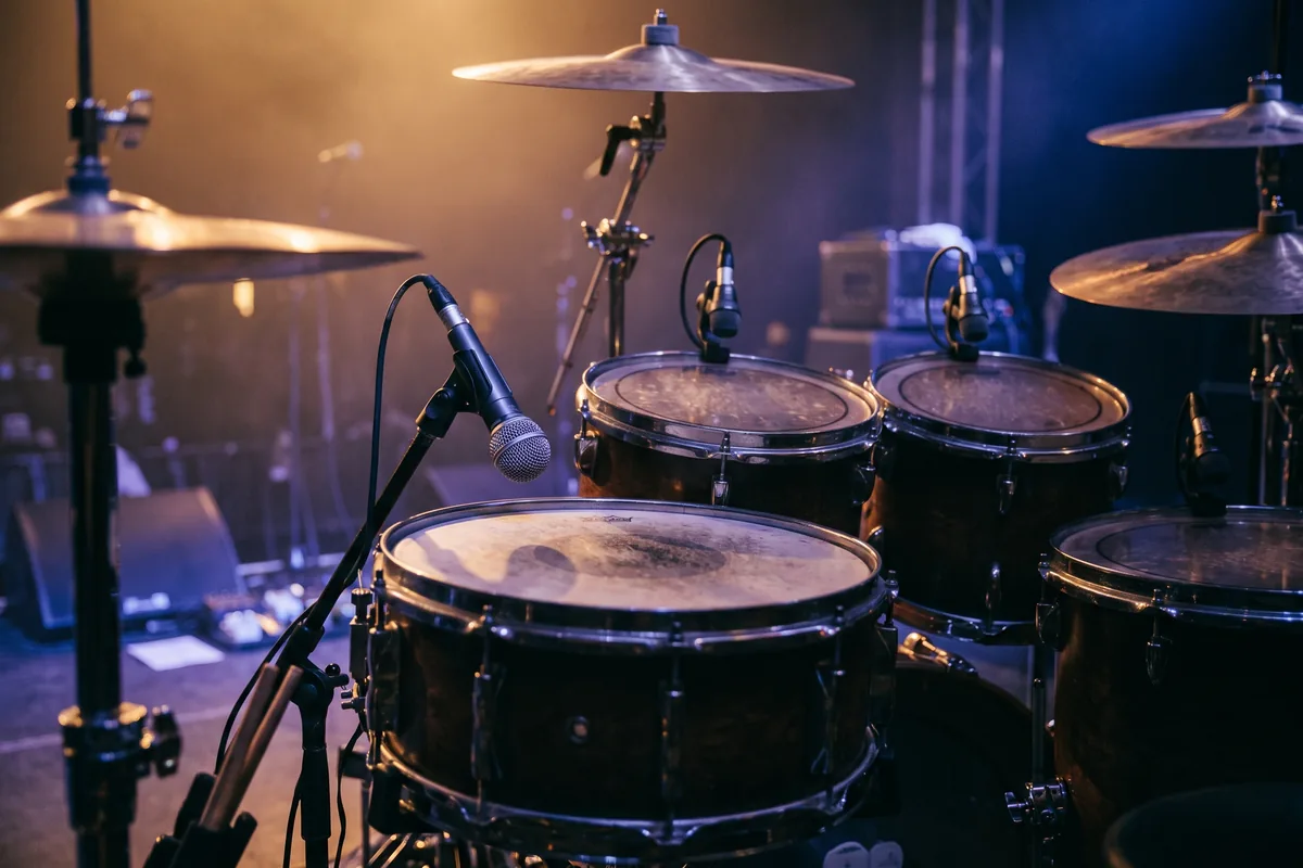 Drum kit on stage with microphones on the snare and toms